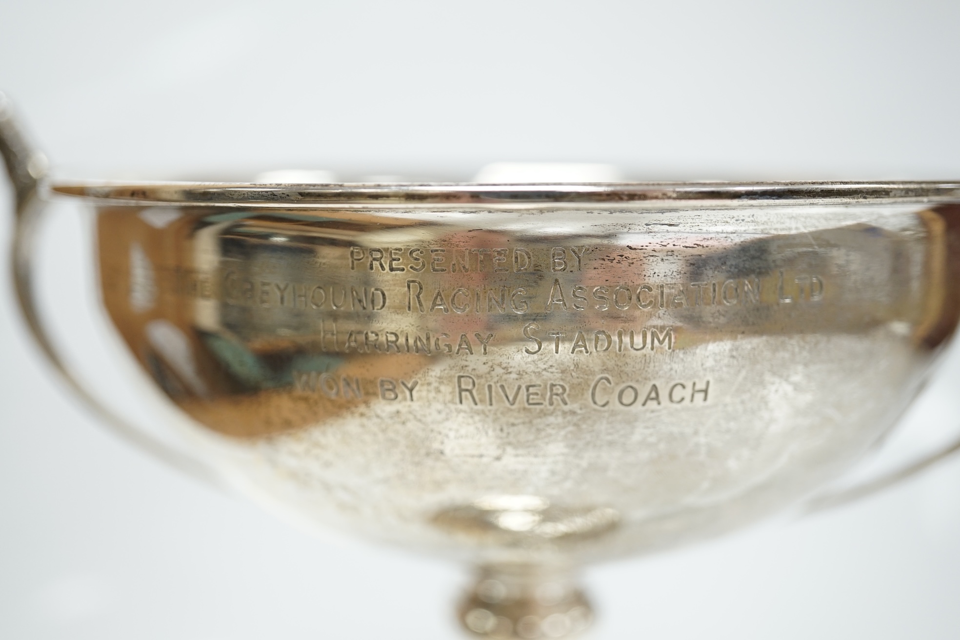 A 1930's silver two handled presentation greyhound trophy cup, with greyhound head handle terminals and engraved inscription, Carrington & Co, London, 1937, 18.7cm, 7.5oz. Condition - poor